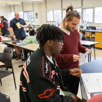 students in small group in science room, discussing 